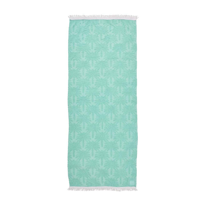 Teal beach resort towel with white pattern on a white background
