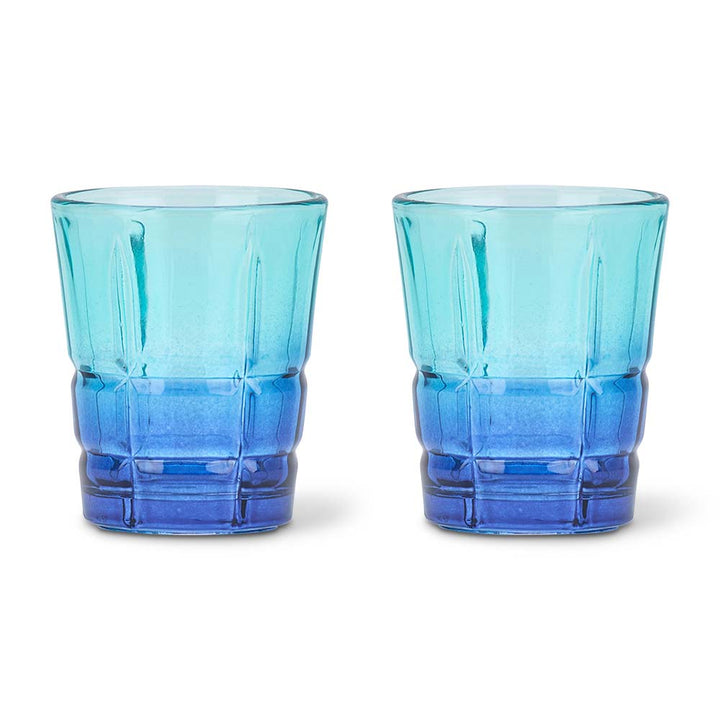 Two blue textured glass tumblers on a white background