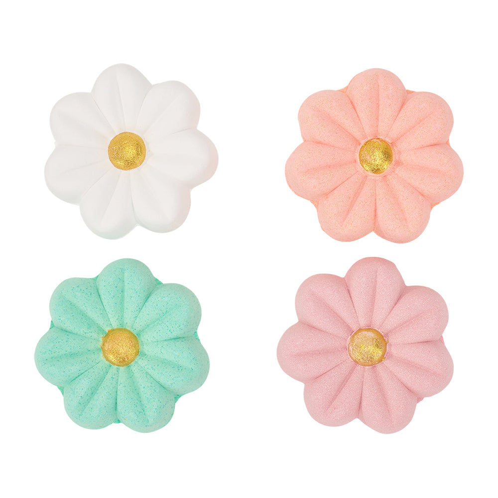 Four flower-shaped shower steamers in white, pink, green, and pink with gold centres on a white background.