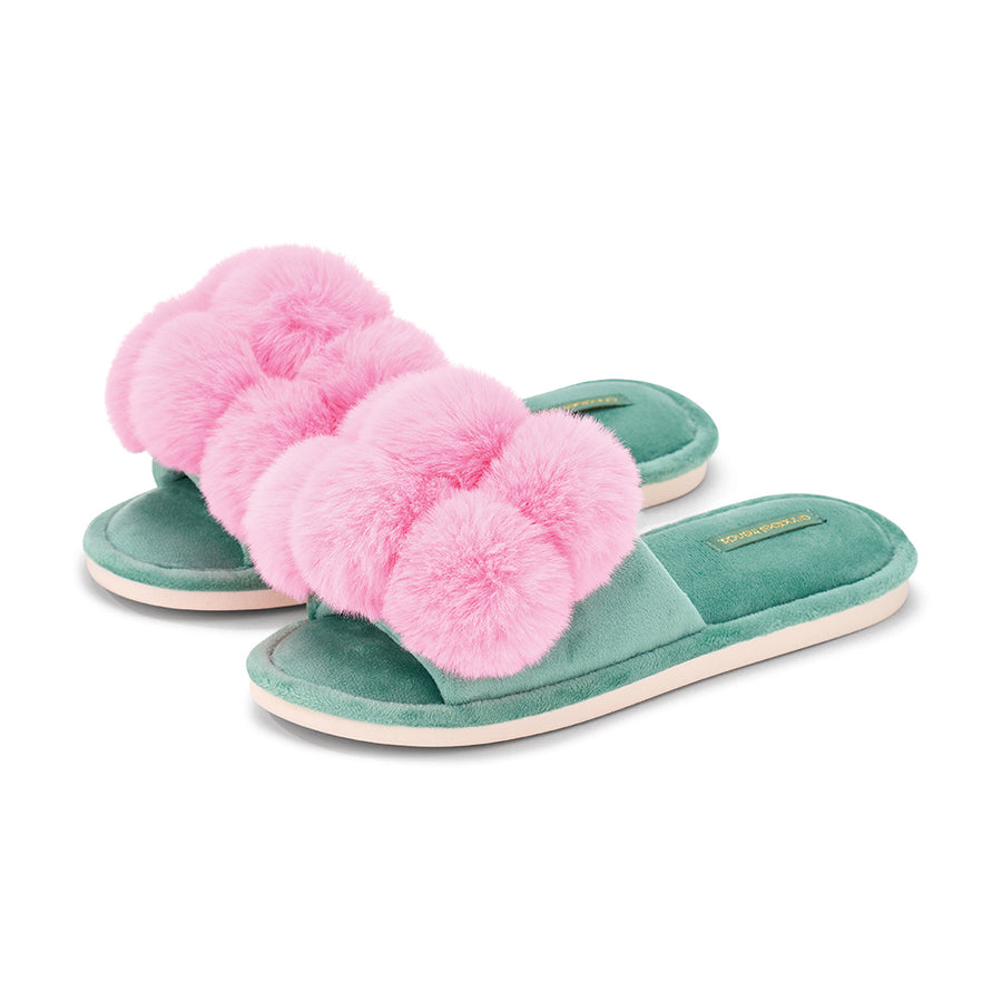 Green slippers with pink fuzzy pom-poms on a white background