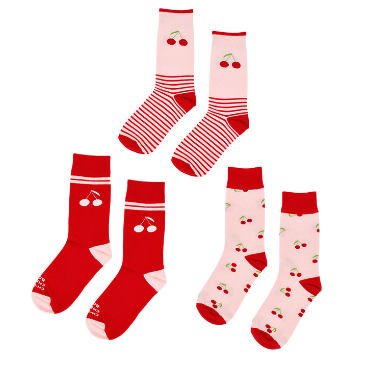 Set of red and pink socks with cherry designs on a white background