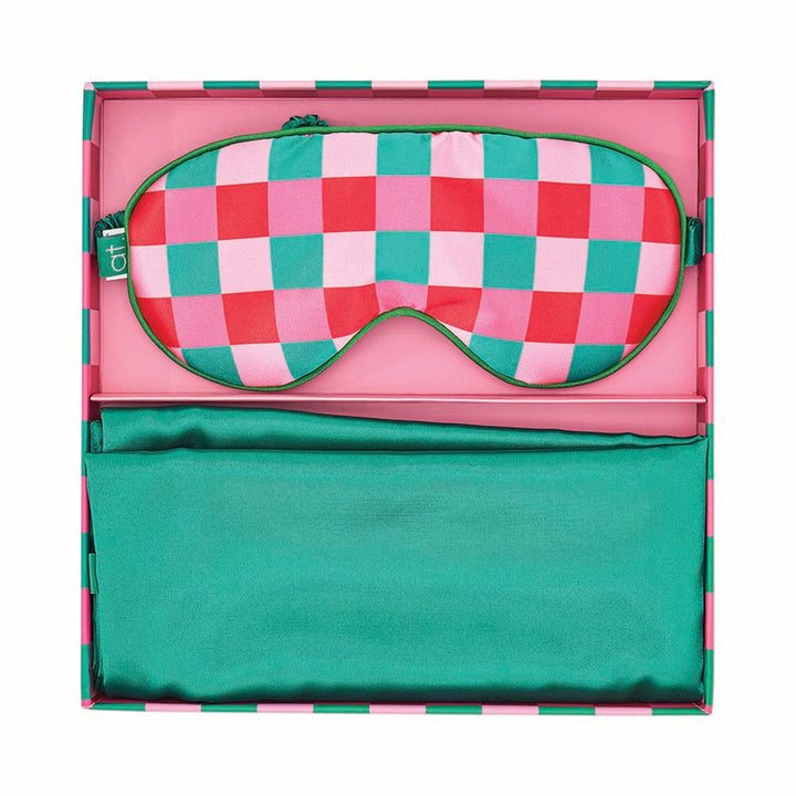 Checkered pink and green sleep mask in a pink case on a white background