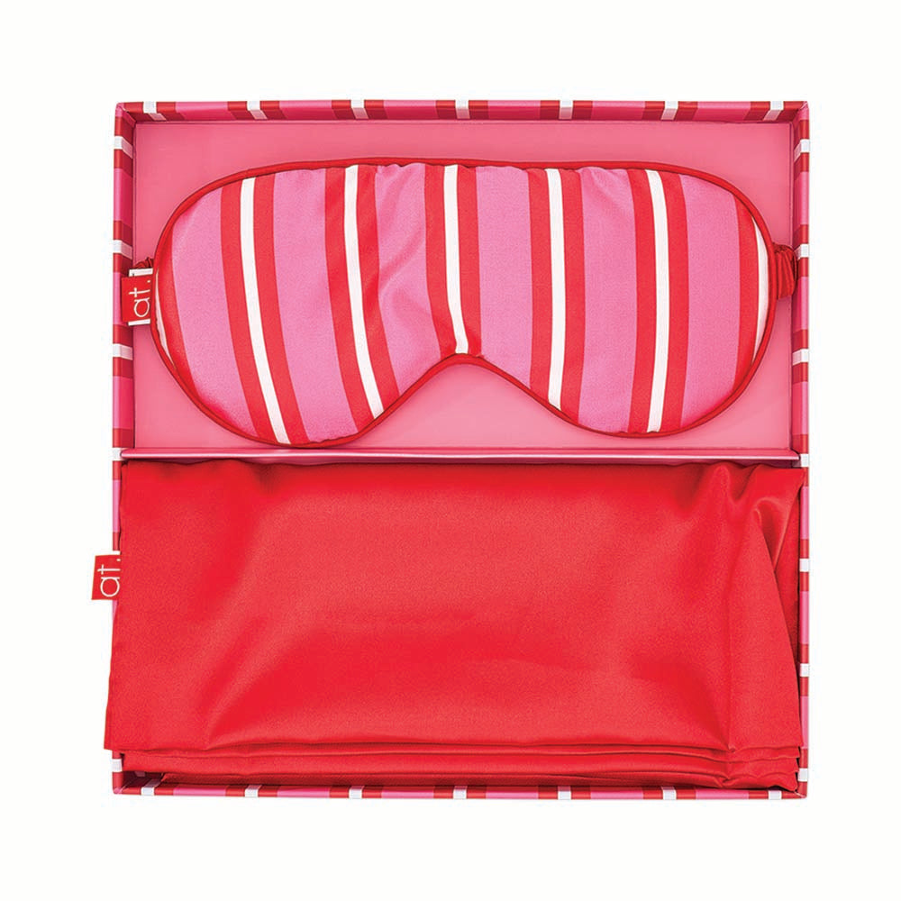 Pink and red striped sleep mask in a clear packaging box on a white background