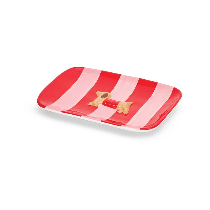 Rectangular tray with red and pink stripes and a small dog figurine on a white background