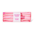 Pink striped eye rest pillow with 'annabel trends' label on a white background