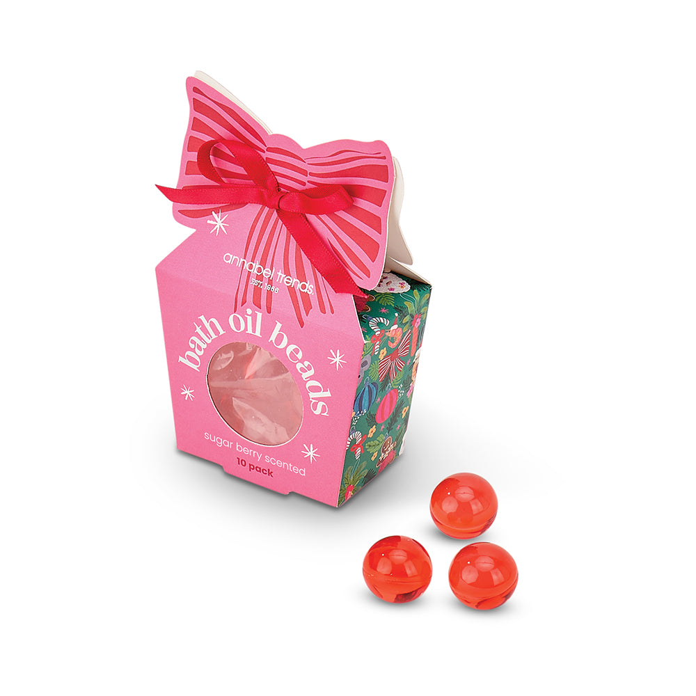 Packaged bath oil beads with a pink box and red bow on a white background
