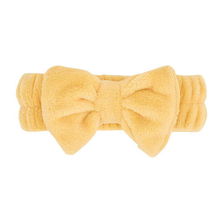 Yellow headband with a large bow on a white background