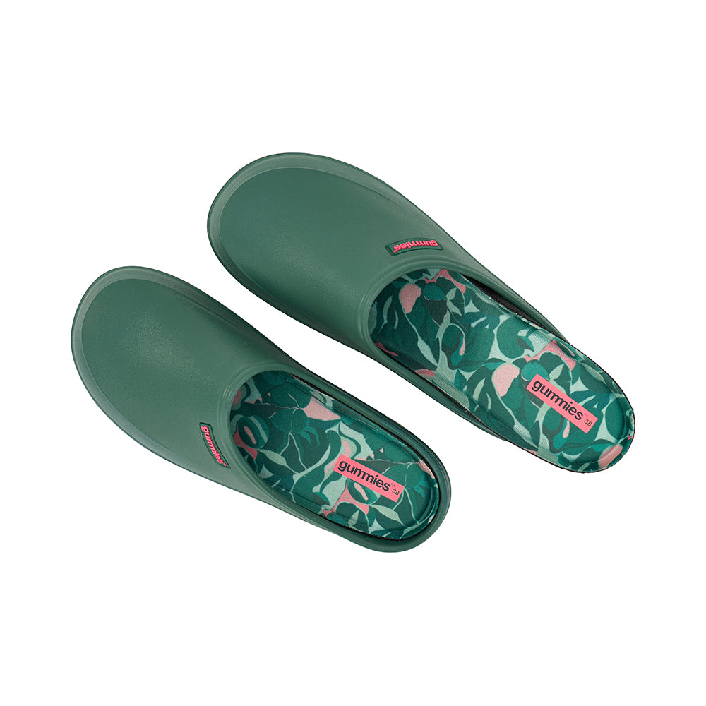 Pair of green garden clogs with floral pattern on a white background