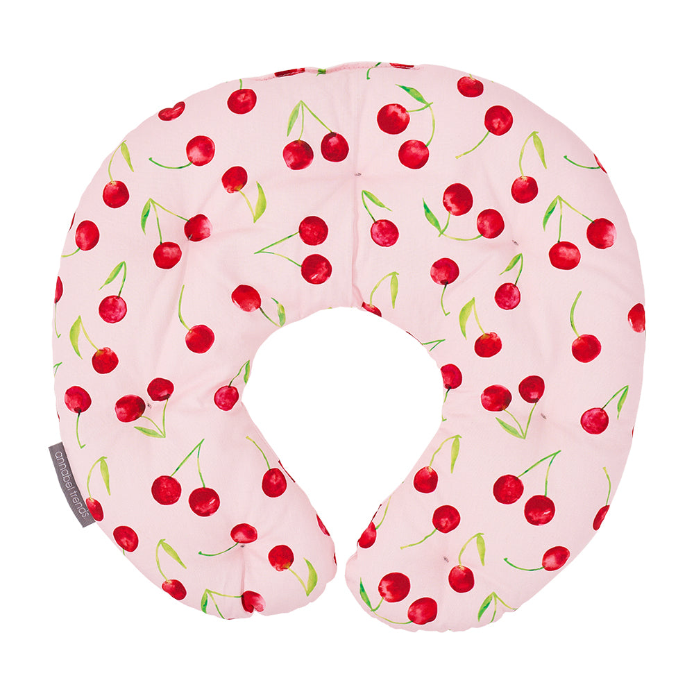 Pink neck pillow with cherry pattern on a white background