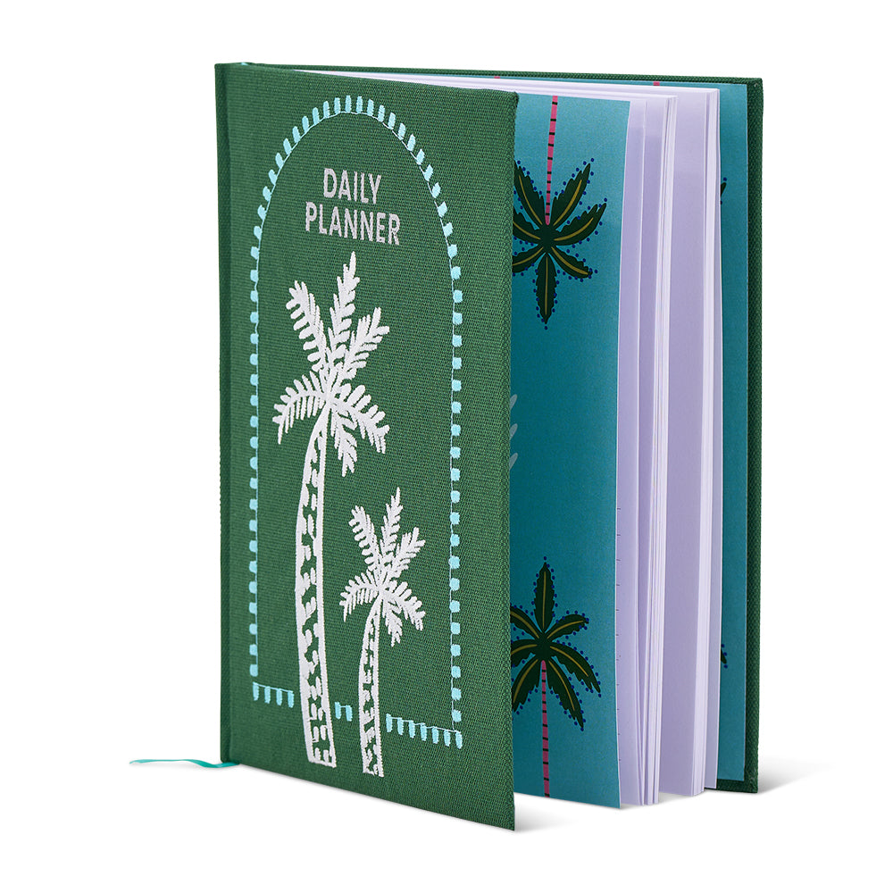 Green planner with palm tree designs on a white background