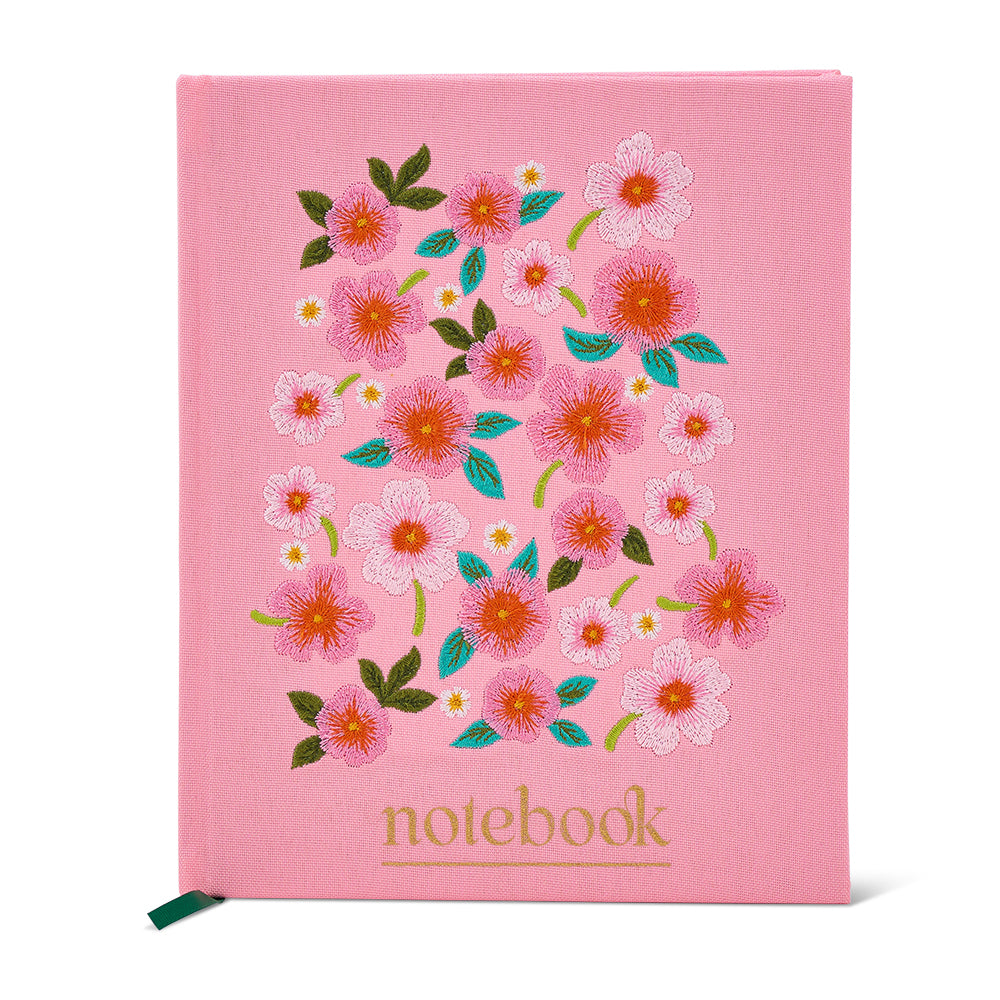 Pink notebook with floral design on a white background