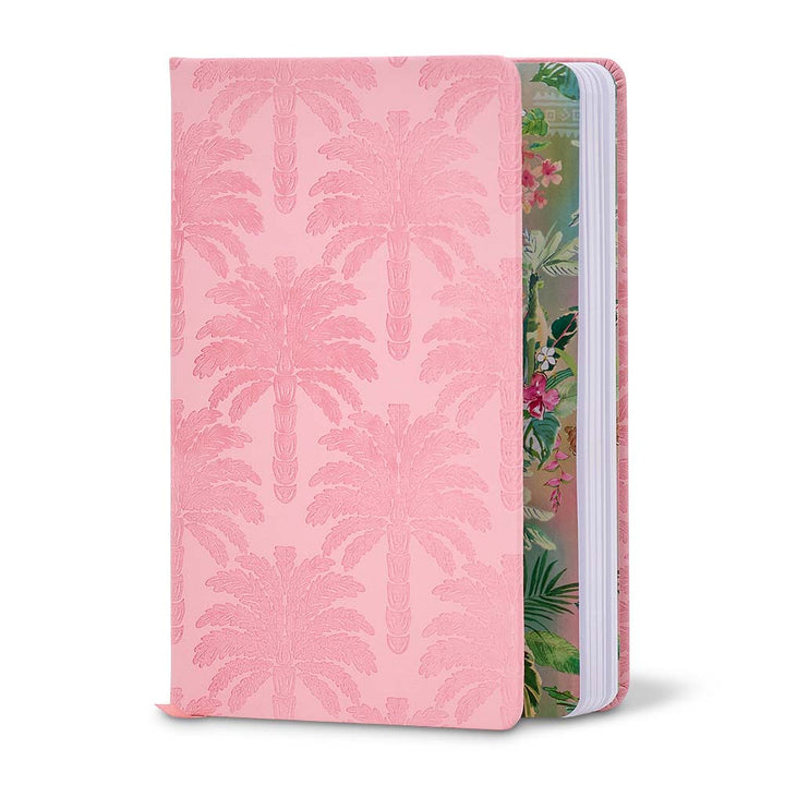 Pink notebook with palm leaf pattern on one side and floral design on the other, on a white background.