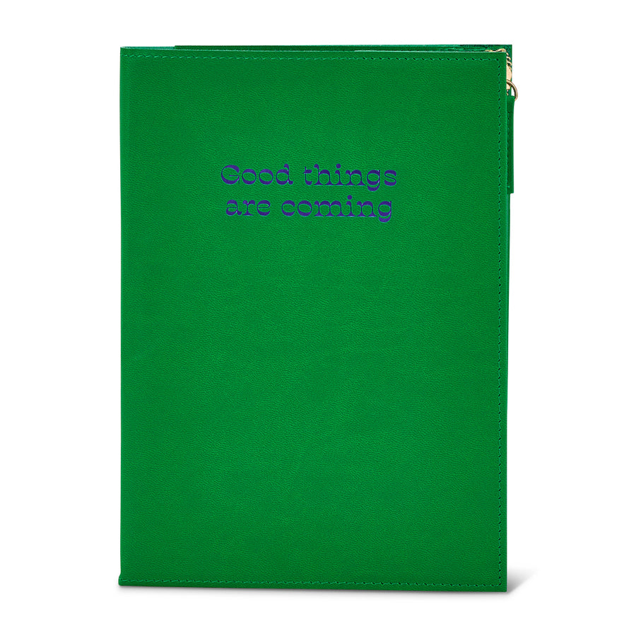 Green notebook with pouch with 'Good things are coming' text on a white background