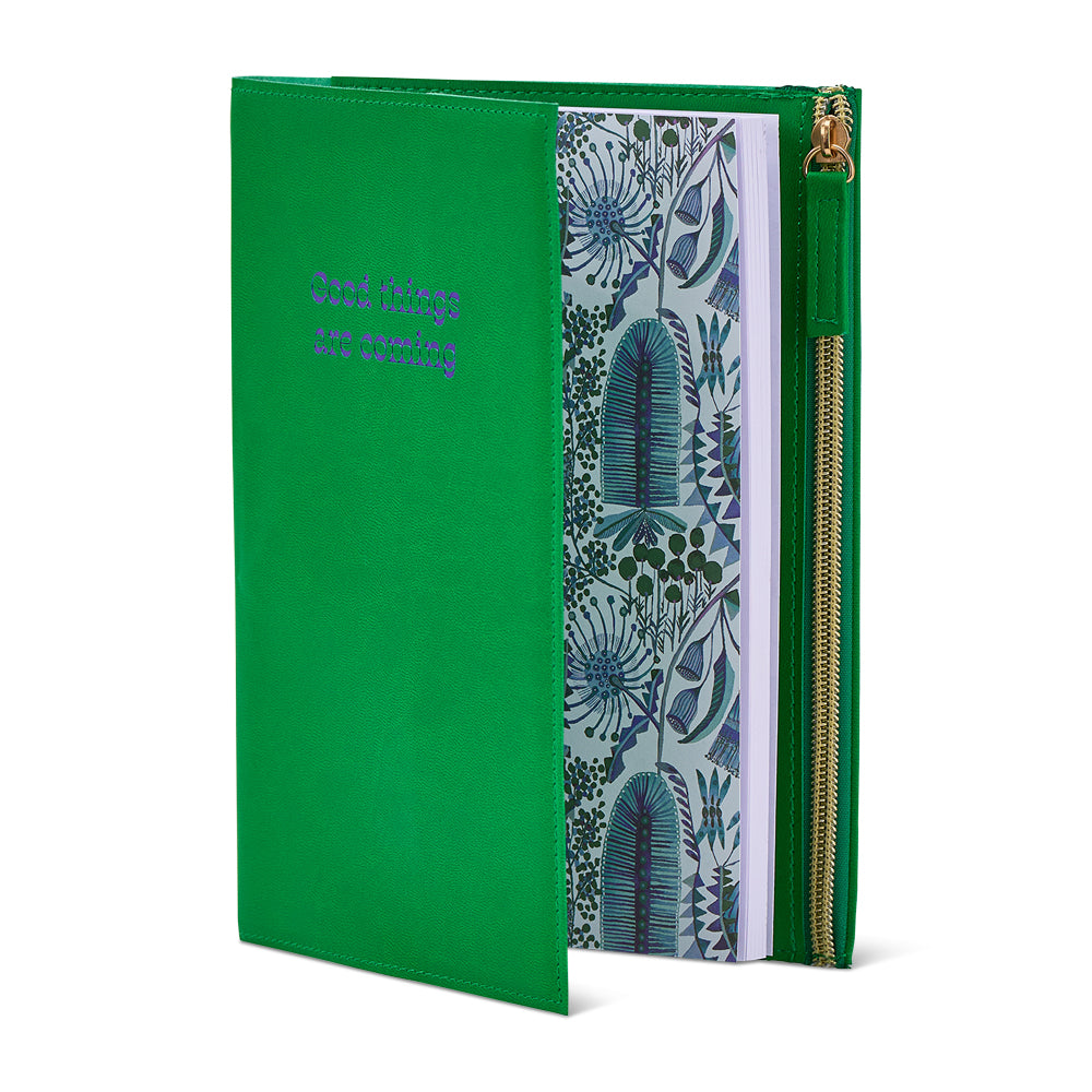 Green notebook with floral design on a white background