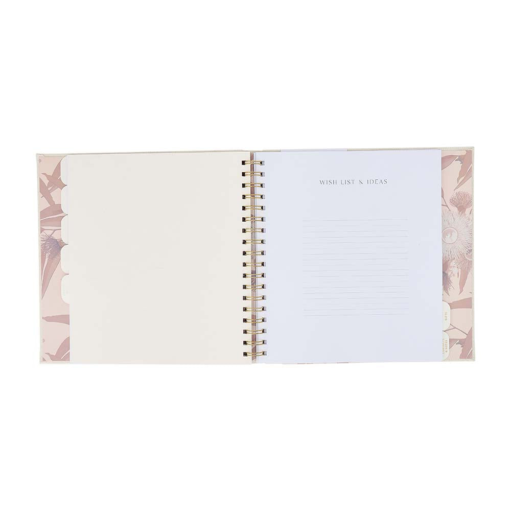 Open spiral-bound notebook with floral design on a white background