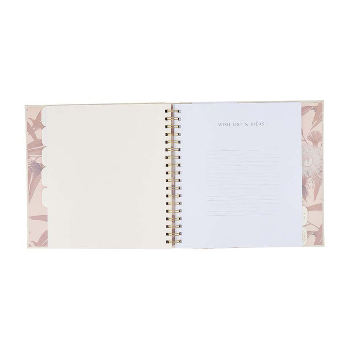 Open spiral-bound notebook with floral design on a white background