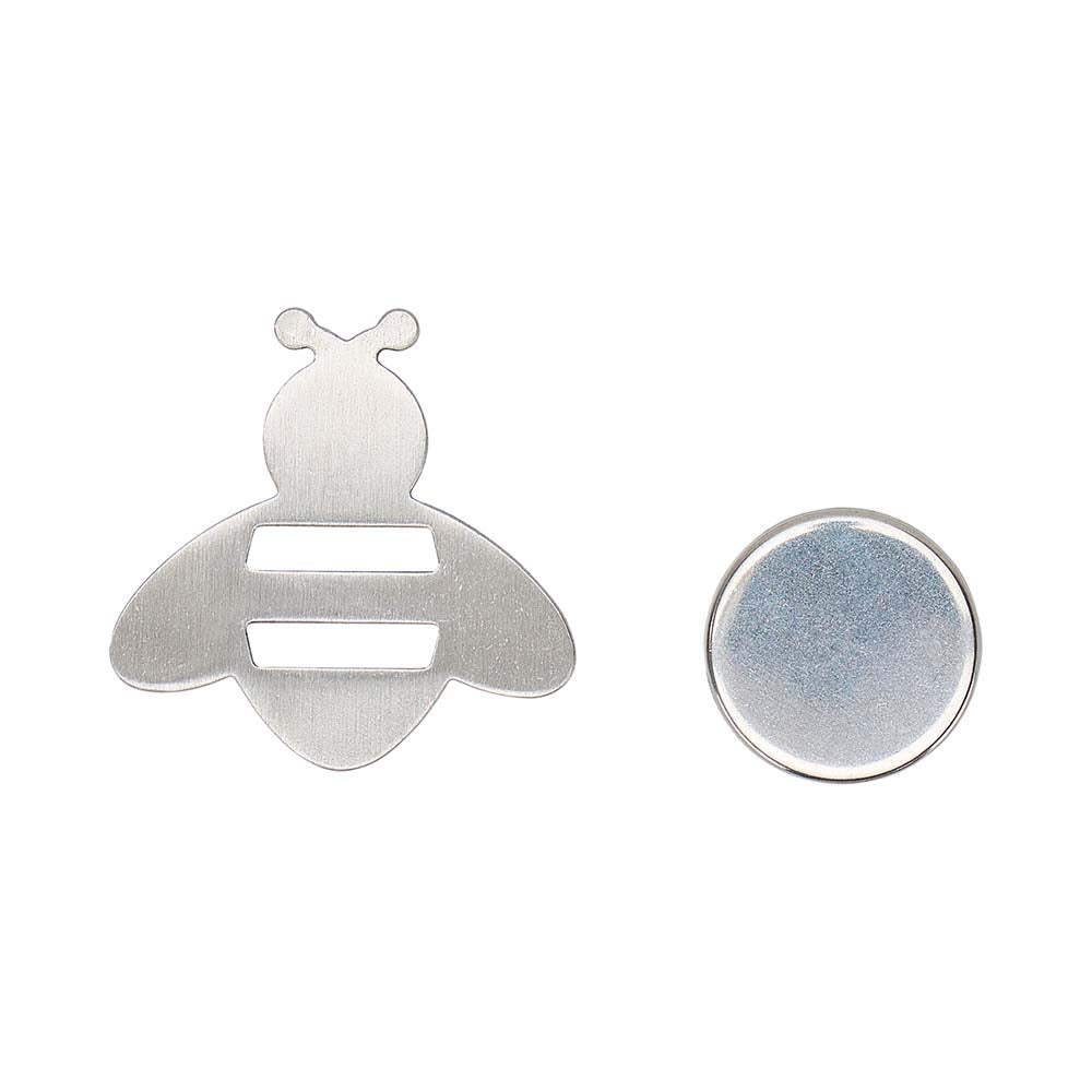 Metallic bee-shaped object and round disc on a white background