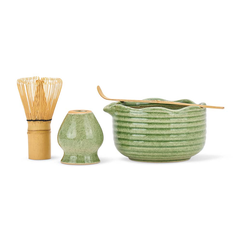 Set of green ceramic tea-making tools on a white background