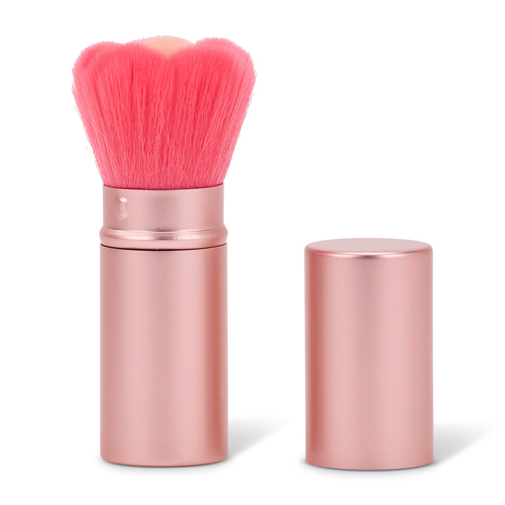 Pink makeup brush with rose gold handle and casing on a white background