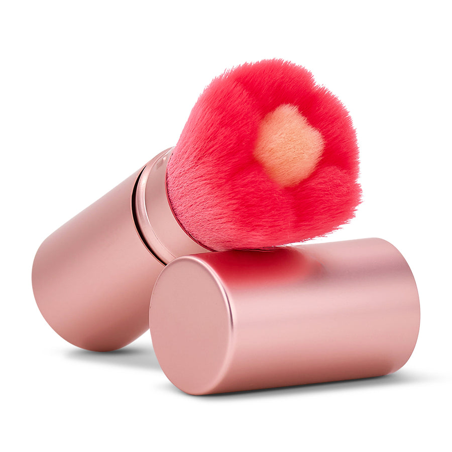 Makeup brush with pink bristles and rose gold handle on a white background