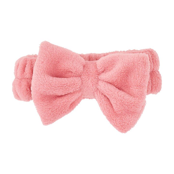 Pink fluffy bow headband on a white background