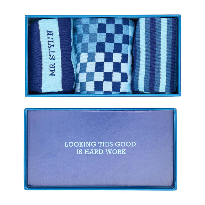 Set of blue and light blue patterned socks in a box with a motivational quote.