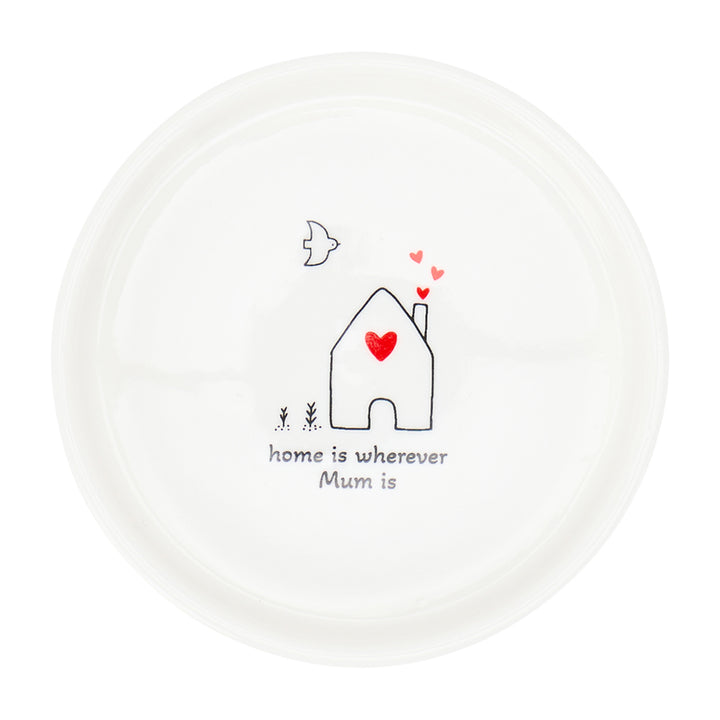 White plate with a house illustration and text 'home is wherever Mum is' on a white background