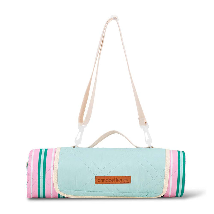 Roll-up picnic mat with striped design and shoulder strap on a white background