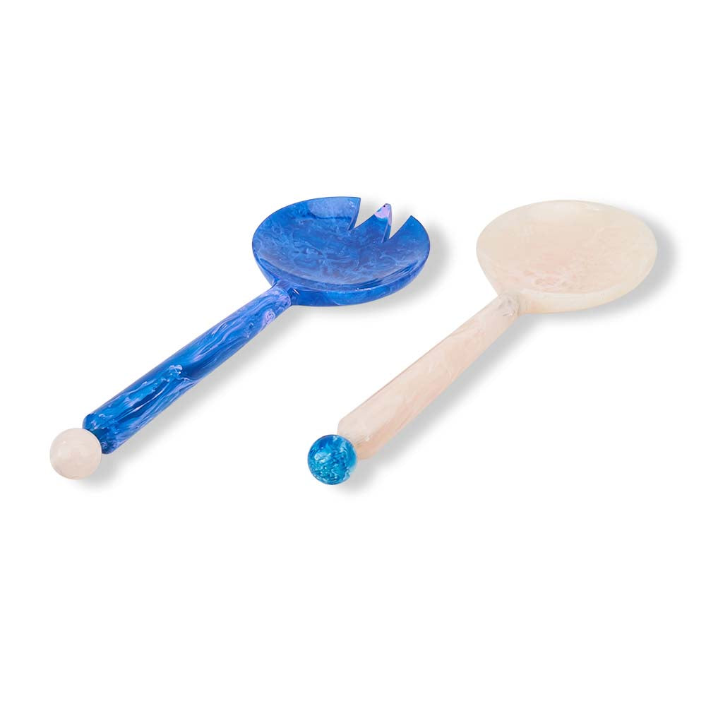Two wooden spoons with blue accents on a white background