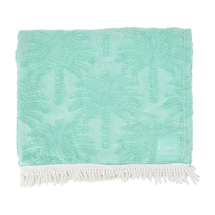Turquoise towel with white fringe on a white background