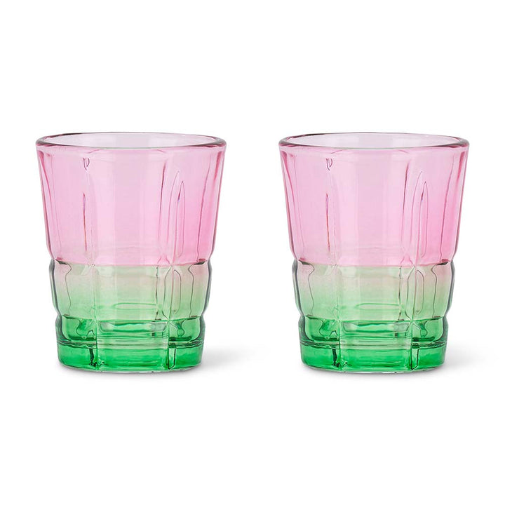 Two pink and green glass tumblers on a white background