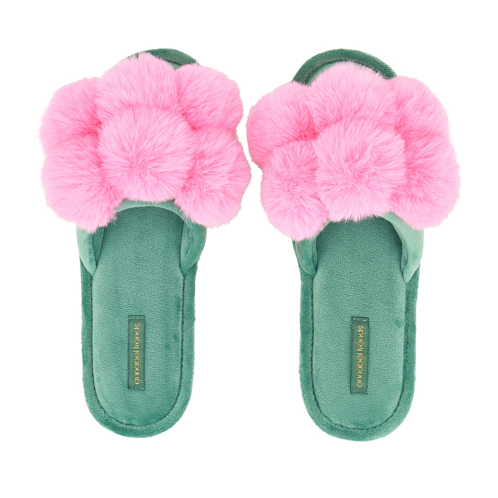 Green slippers with pink fluffy flowers on a white background