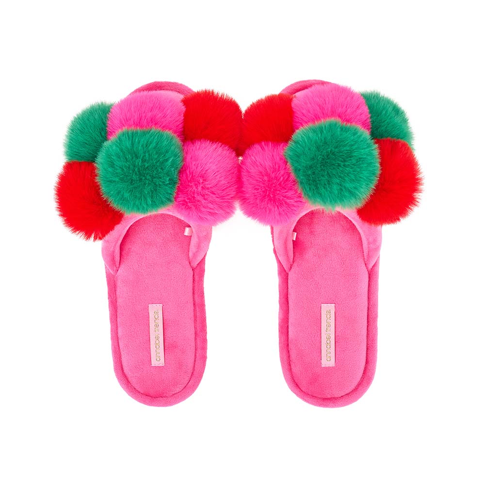 Pink slippers with colorful pom-poms on a white background