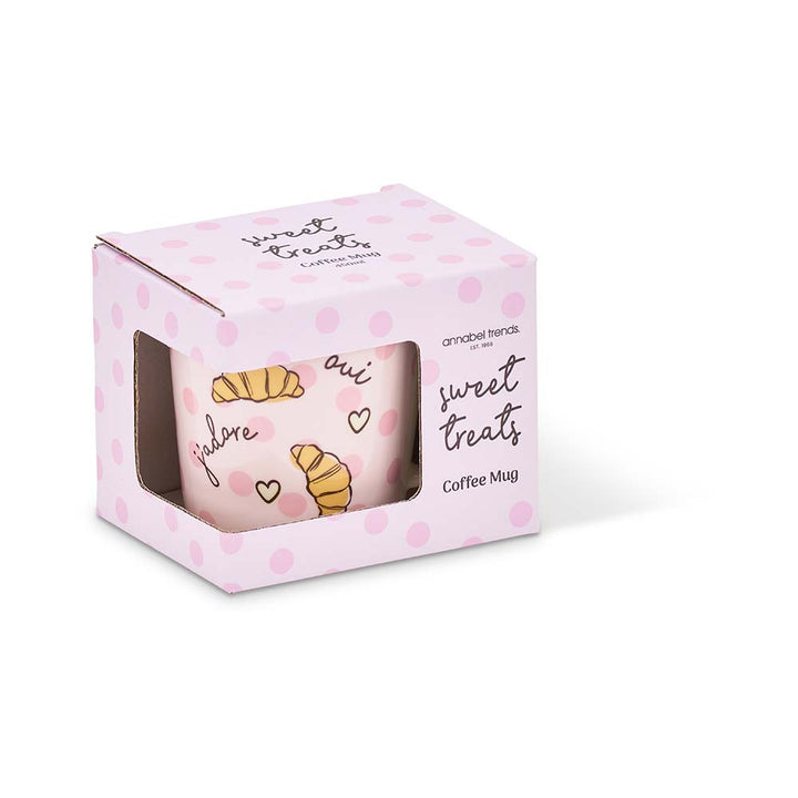 Pink coffee mug with croissant design in a matching polka dot box on a white background