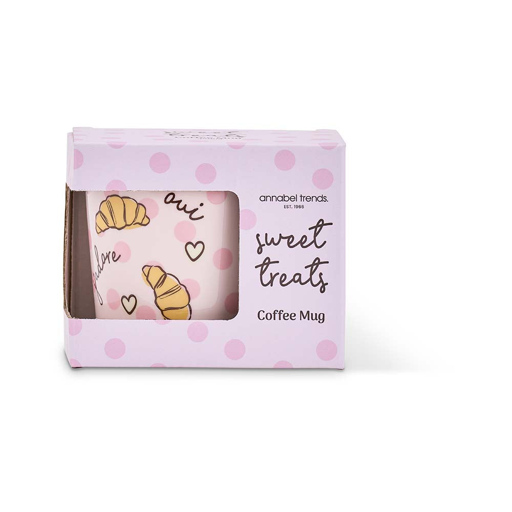 Coffee mug with polka dot design and text in a branded box on a white background