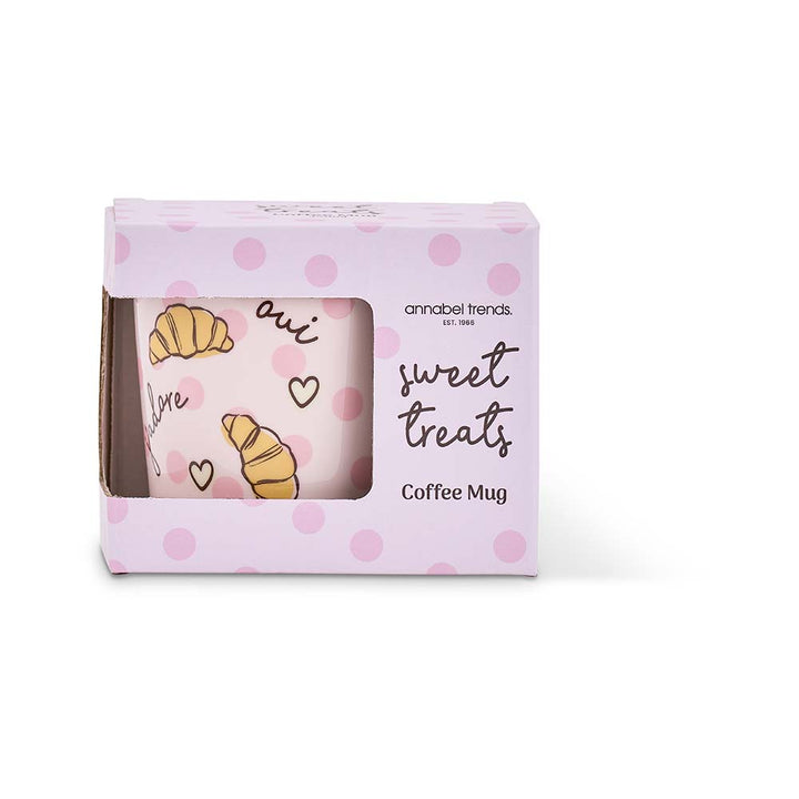 Coffee mug with polka dot design and text in a branded box on a white background