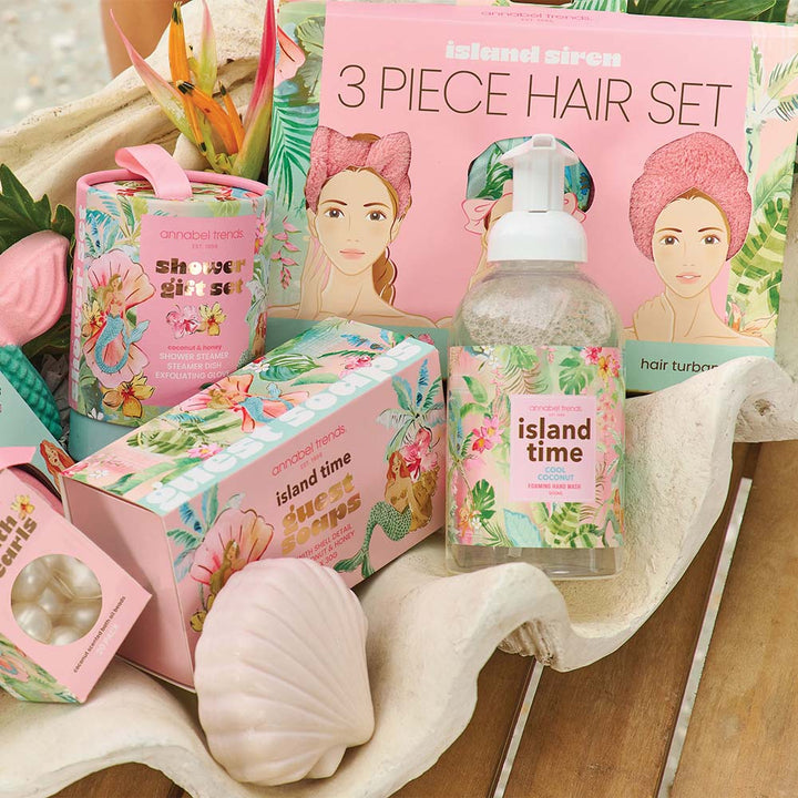Island Time hair care products including a bottle, boxes, and a towel on a wooden surface.