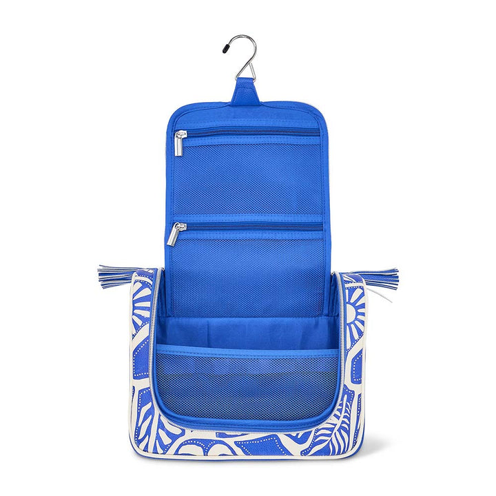 Blue hanging toiletry bag with white geometric pattern on a white background