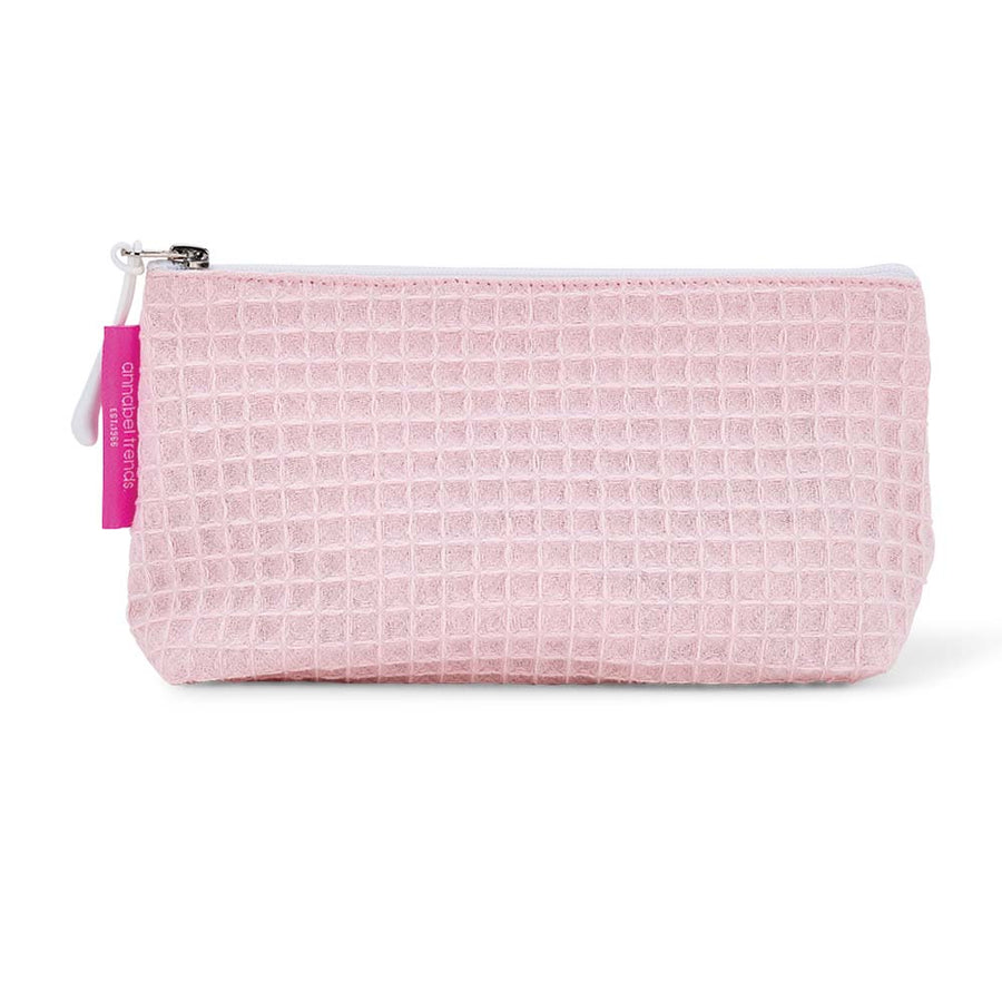 Pink waffle-textured cosmetic bag with a white zipper on a white background