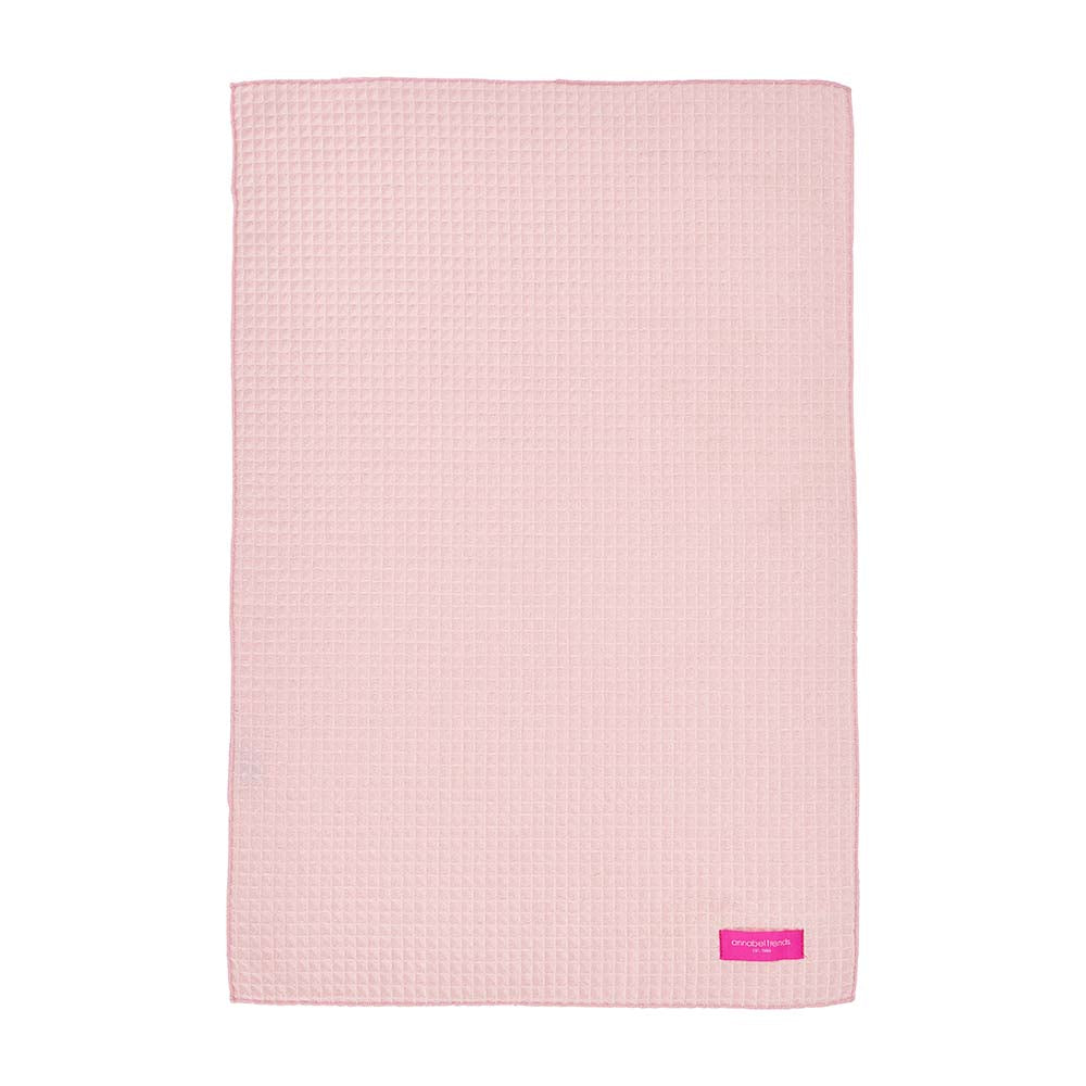 Pink textured hand towel with annabel trends label on a white background