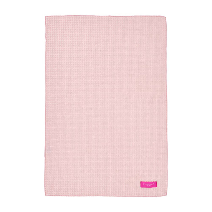 Pink textured hand towel with annabel trends label on a white background