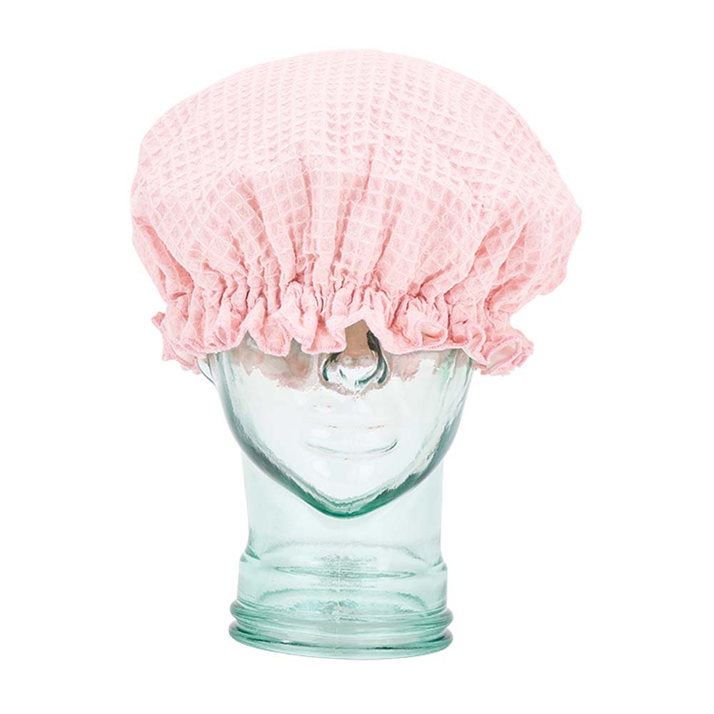 Clear glass mannequin head with a pink textured shower cap on a white background