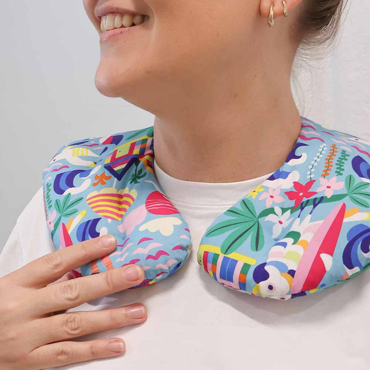 Person wearing a colorful neck pillow with a white background