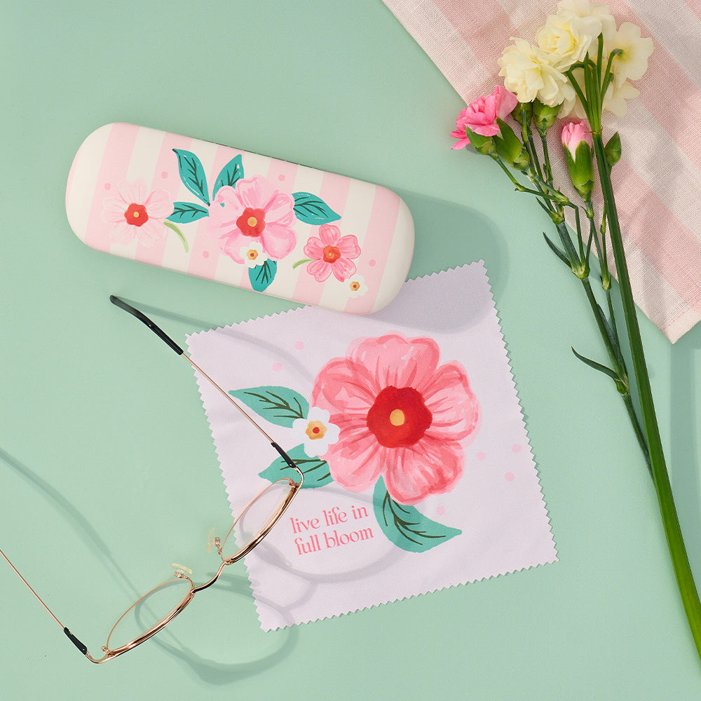 Floral-themed glasses case and cleaning cloth on a light green background with flowers.