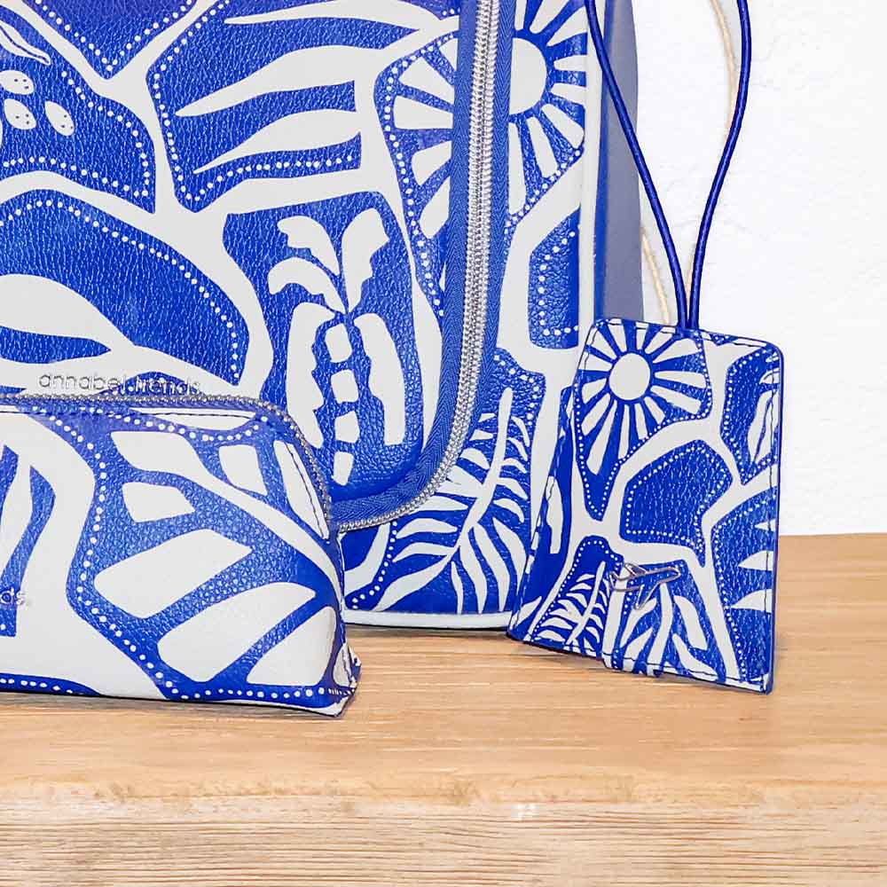 Blue and white patterned handbag with a matching pouch on a wooden surface