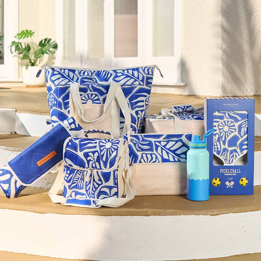 Collection of blue and white patterned bags and items on a wooden surface with a neutral background.