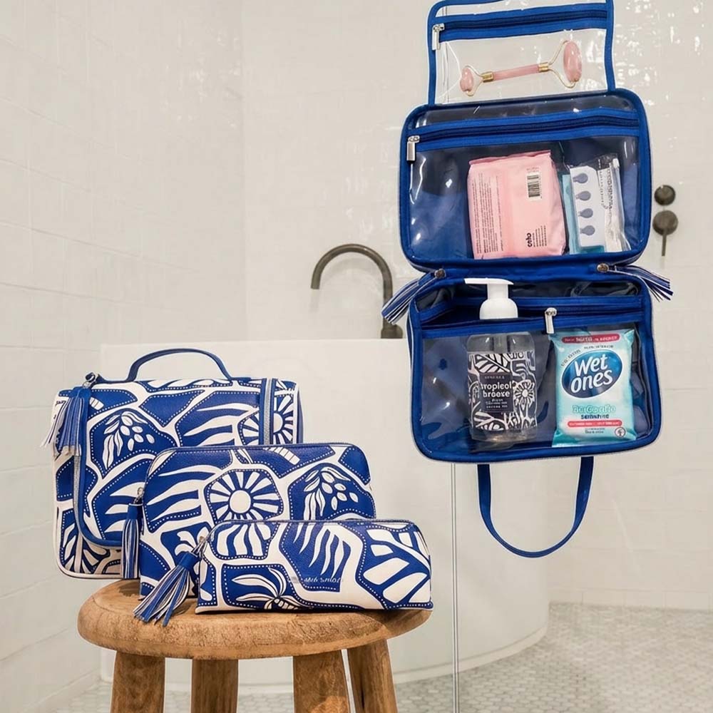 Blue toiletry bag with floral pattern on a stool in a bathroom setting