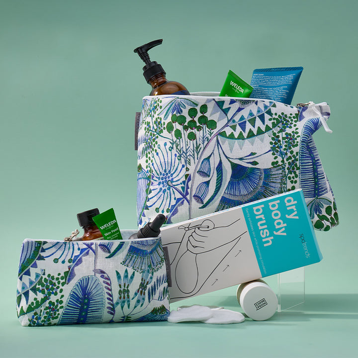 Green and blue bush botanical print cosmetic bags with toiletry products