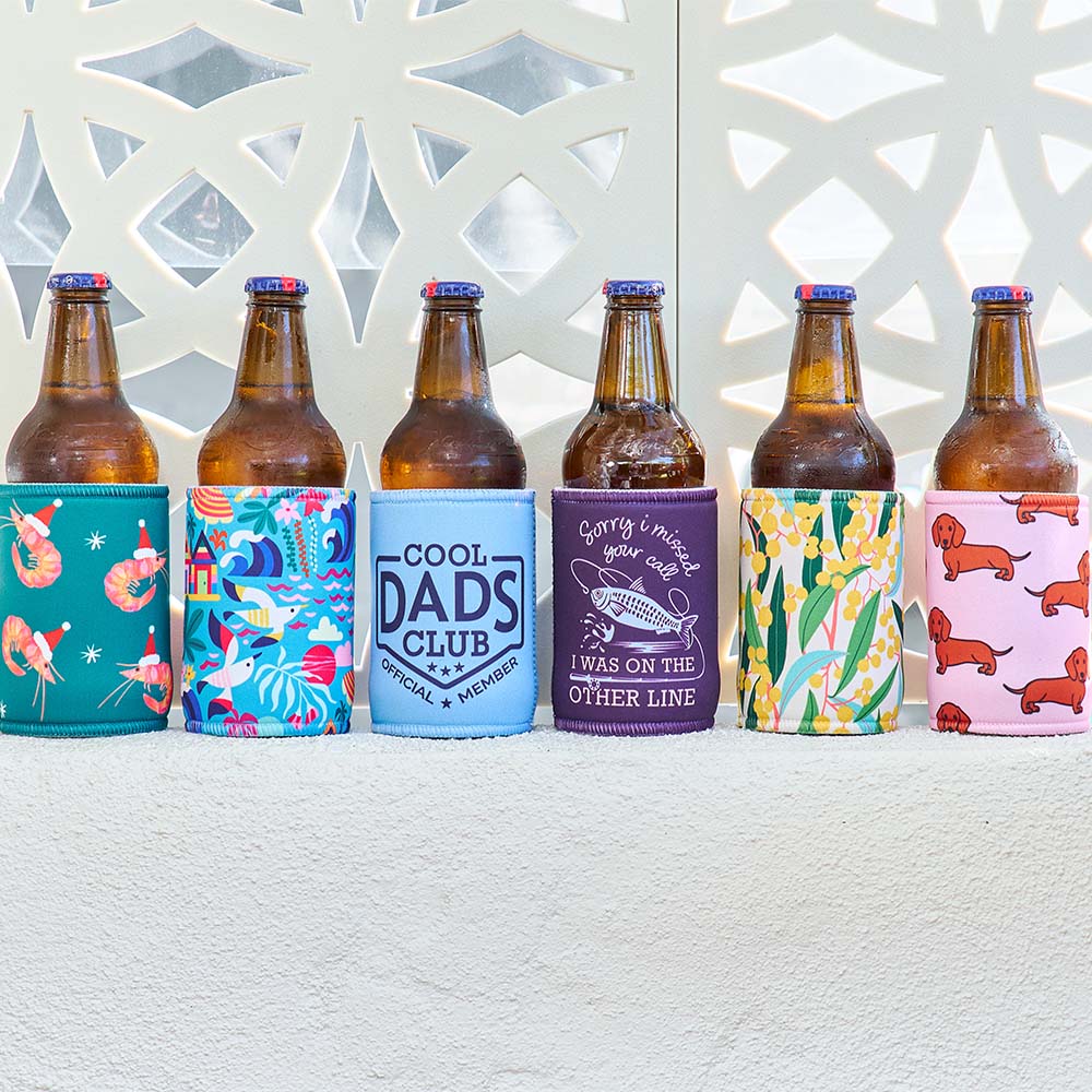 Set of beer bottles with colorful sleeves featuring various designs on a textured surface.