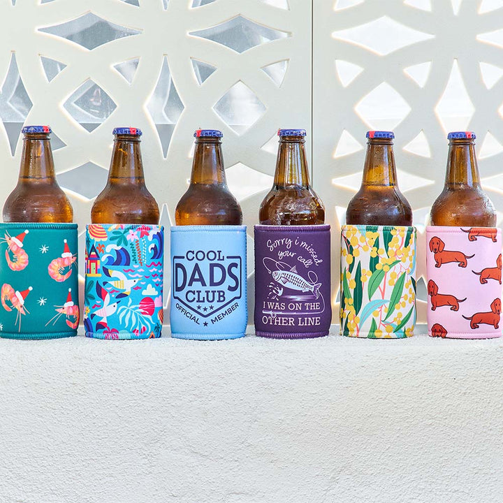 Set of beer bottles with colorful sleeves featuring various designs on a textured surface.